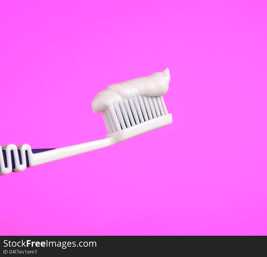 Toothbrush With Toothpaste On Pink Background