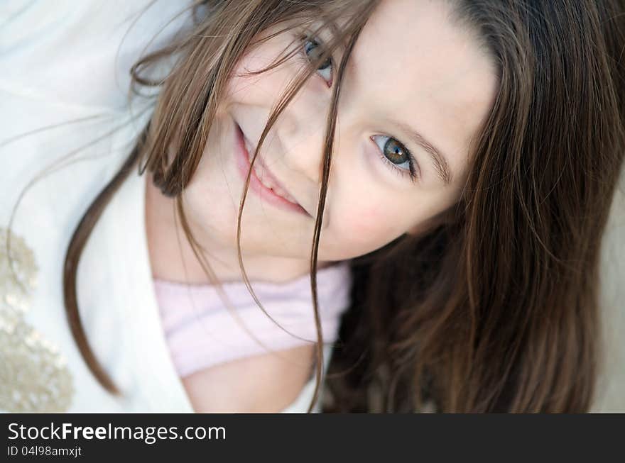 Angled natural portrait of sweet little girl with long brown hair and green eyes. Angled natural portrait of sweet little girl with long brown hair and green eyes