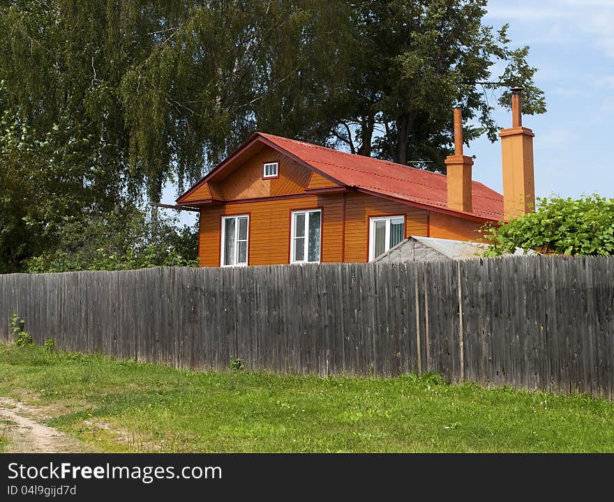 New country house behind a high wooden fence. New country house behind a high wooden fence