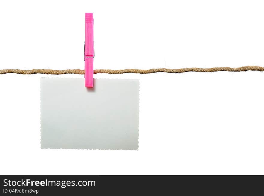 A blank photo hanging on a rope held by a clothes peg on a white background with copy space. A blank photo hanging on a rope held by a clothes peg on a white background with copy space