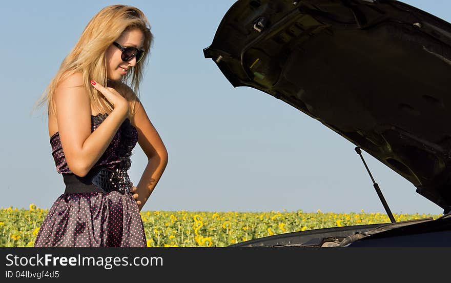 Fashionable woman looking at car engine