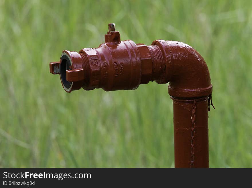 A red water tap in a field