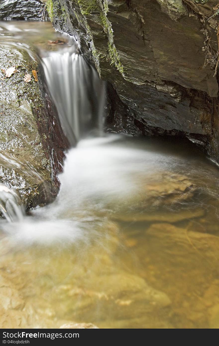 Small weir flowing over rocks in rock. Small weir flowing over rocks in rock