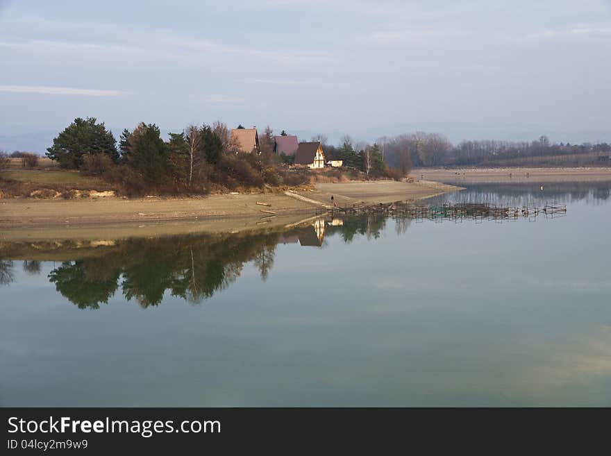 Launched dam calm surface, fishing houses on the shore