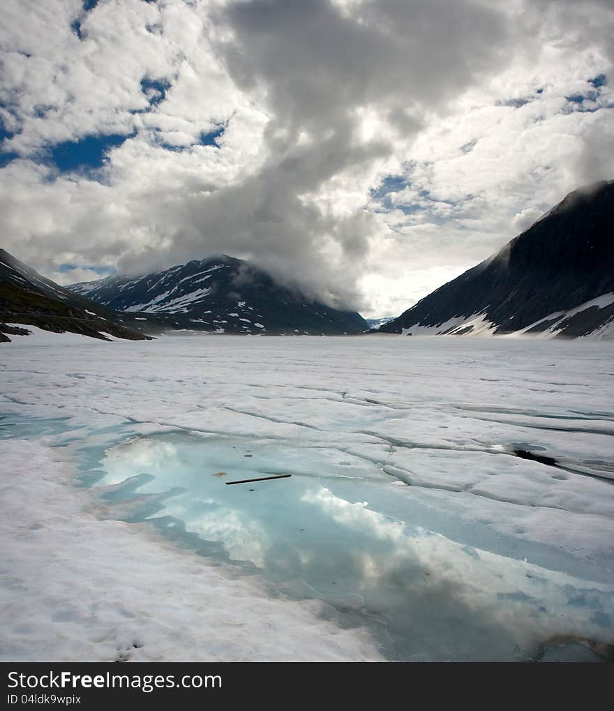 Norwegian landscape with a mountain on background and mountain lake