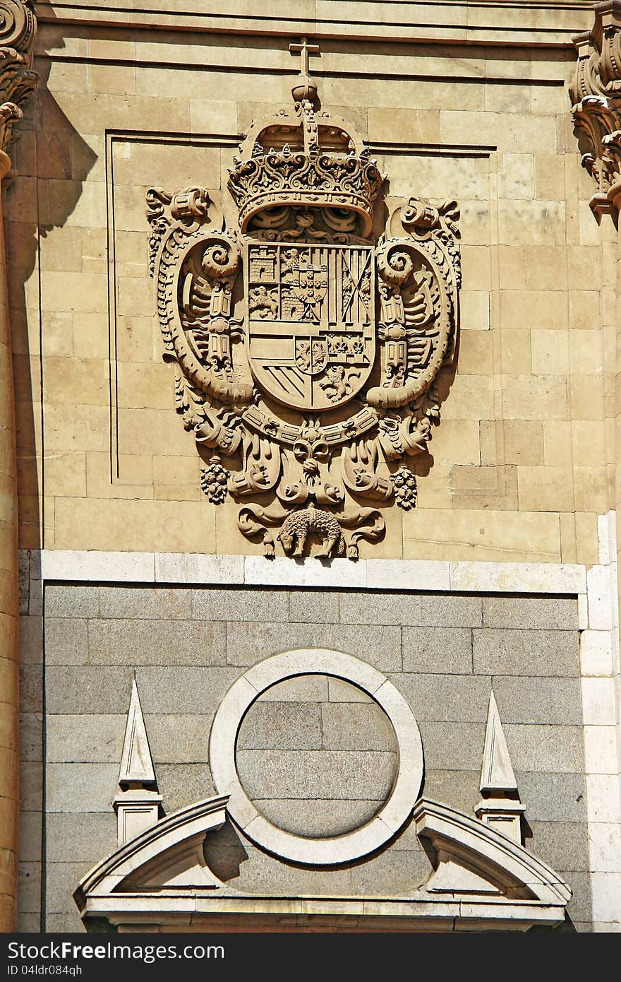 An engraving of the official seal and emblem of the Spanish monarchy on a sandstone facade in Salamanca, Segovia. An engraving of the official seal and emblem of the Spanish monarchy on a sandstone facade in Salamanca, Segovia.
