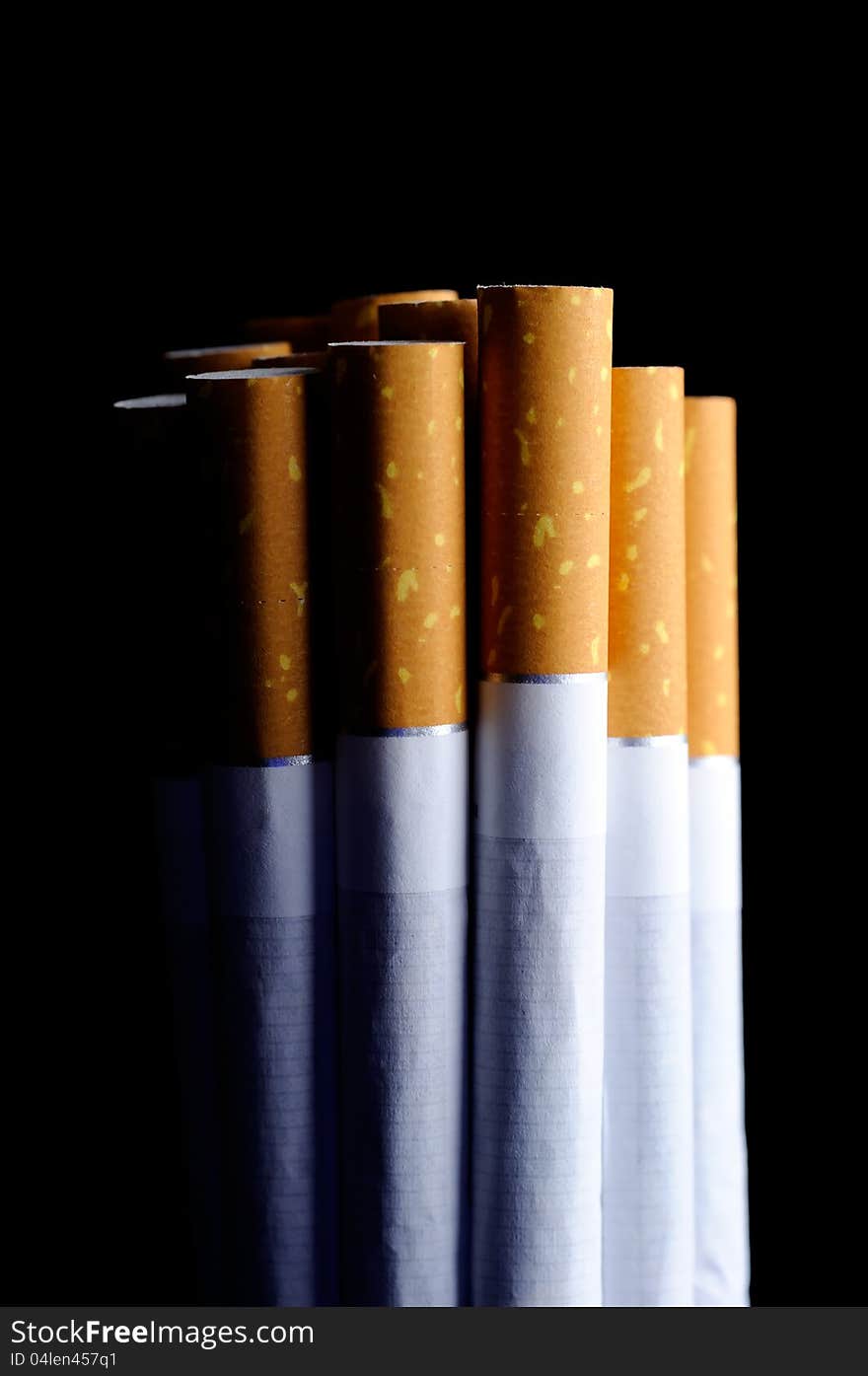 Cigarettes on a black background with a single light source to stress the bad effects of smoking. Cigarettes on a black background with a single light source to stress the bad effects of smoking