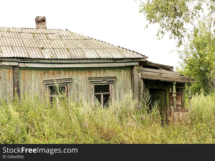 Old village house, abandoned by tenants,  under  a tree. Old village house, abandoned by tenants,  under  a tree