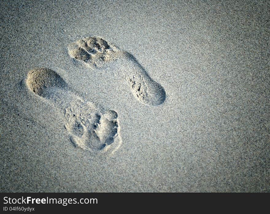 A pair of foot prints left in sand