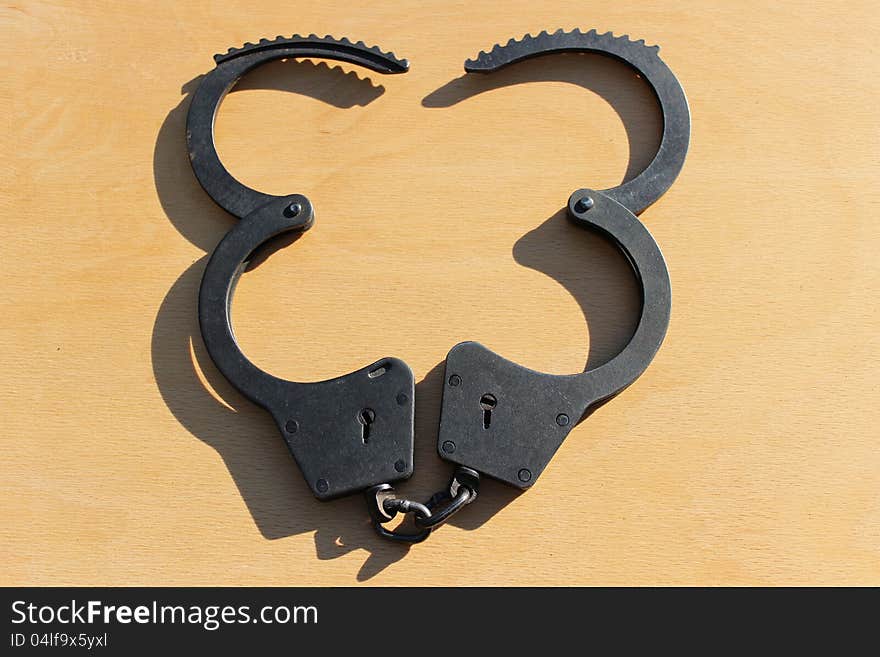 Open Handcuffs closeup on wooden table