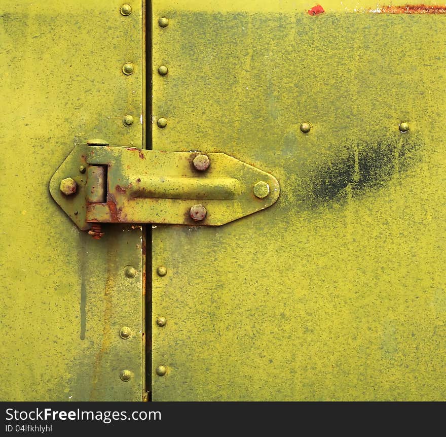 A hinge on a rusty metal door. A hinge on a rusty metal door