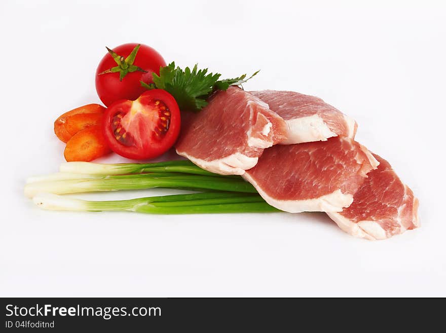 Raw meat and vegetables on white