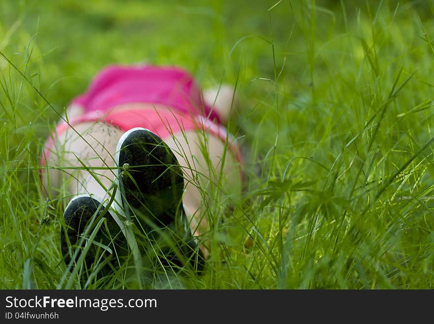 Girl lying on green grass (bottom view). Girl lying on green grass (bottom view)