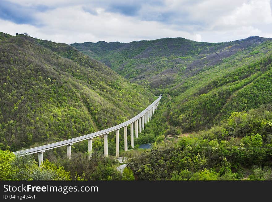 An elevated road among beautiful green mountains. Perfect for environment/transportation concepts. An elevated road among beautiful green mountains. Perfect for environment/transportation concepts.