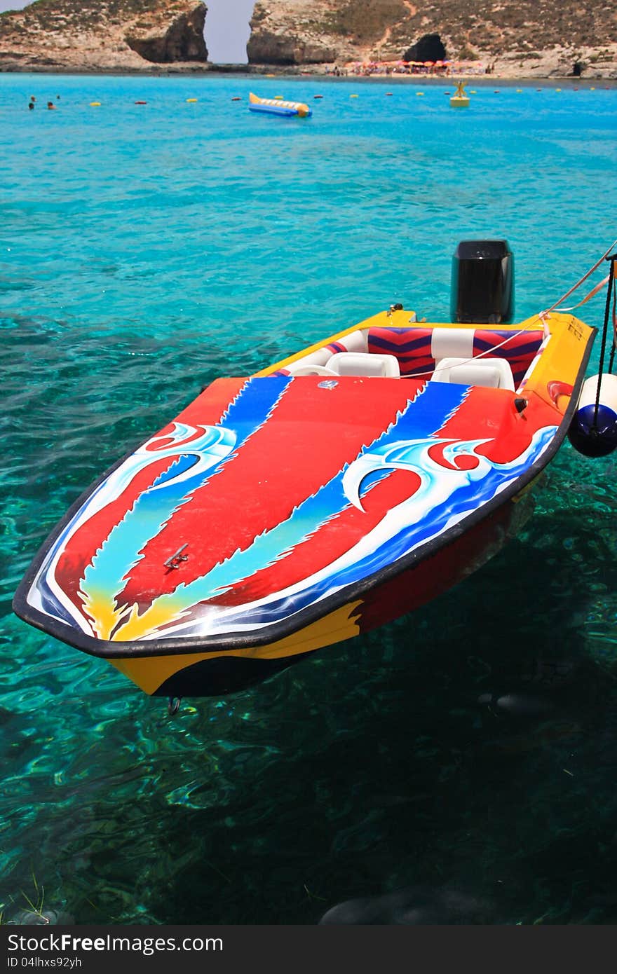 Colourful speed boat floating on turquoise water near Blue Lagoon, Malta. Colourful speed boat floating on turquoise water near Blue Lagoon, Malta.