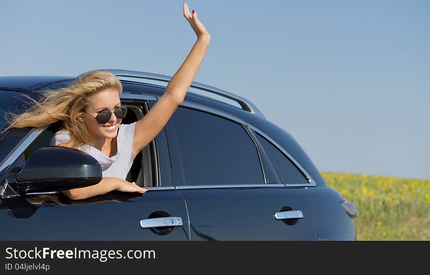 Woman waving from car window