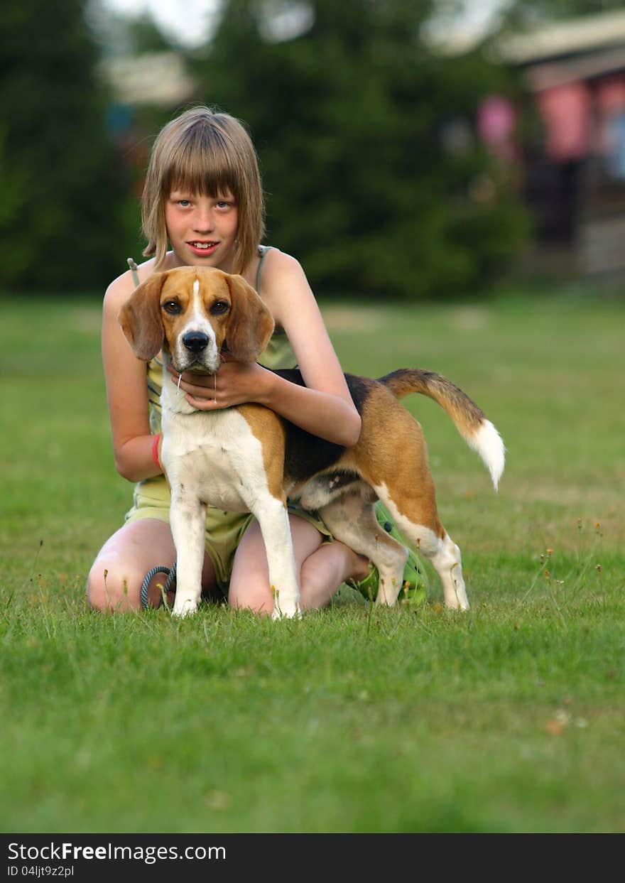 Girl and her beagle sitting in the grass. Girl and her beagle sitting in the grass.