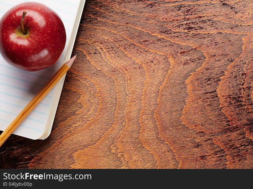 Apple and a pencil on a school notebook