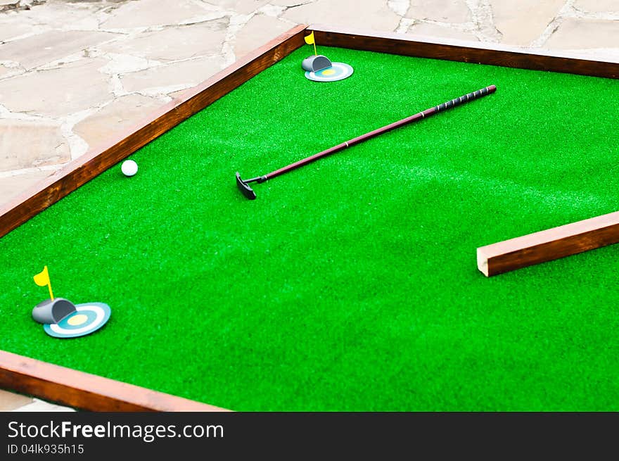 Mini golf field with ball and golf club