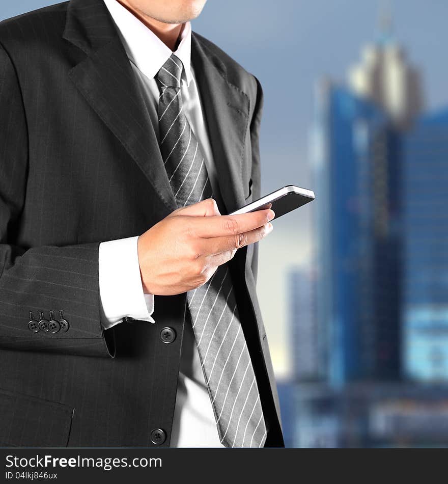 Cropped view of Businessman holding the phone standing in front the major cities