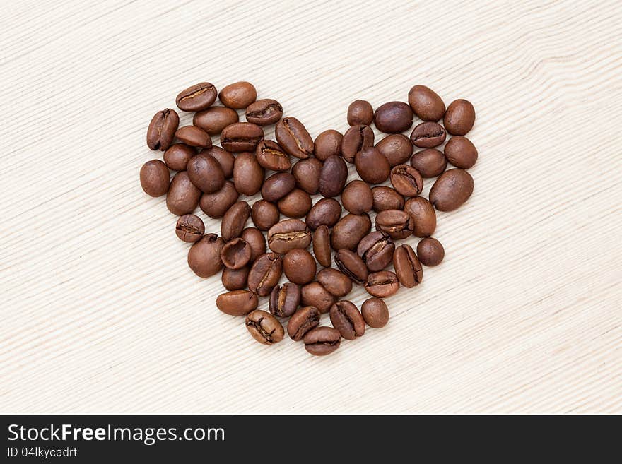 Coffee beans on light wood background. Coffee beans on light wood background