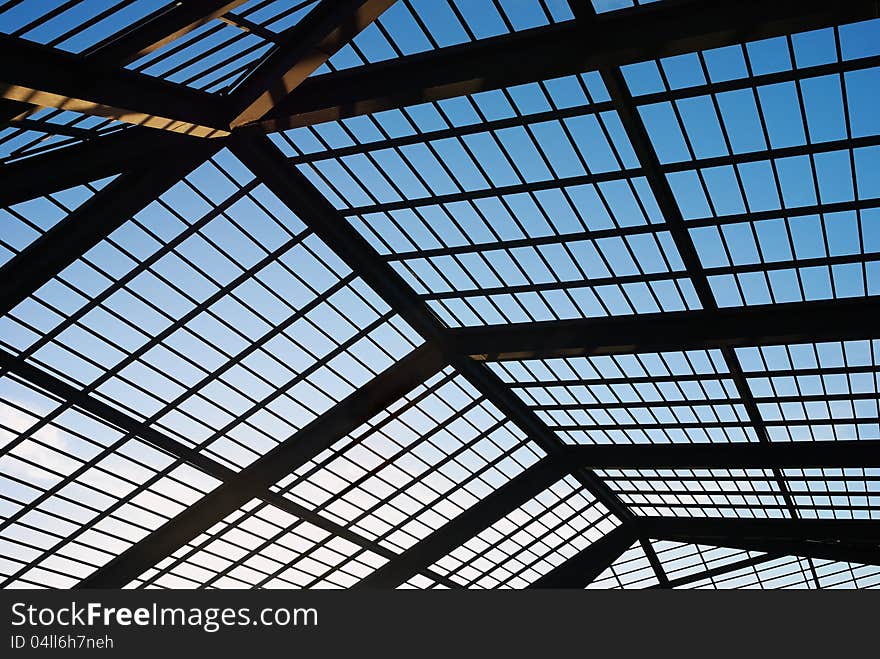 The roof structure of building against a clear blue sky in the background