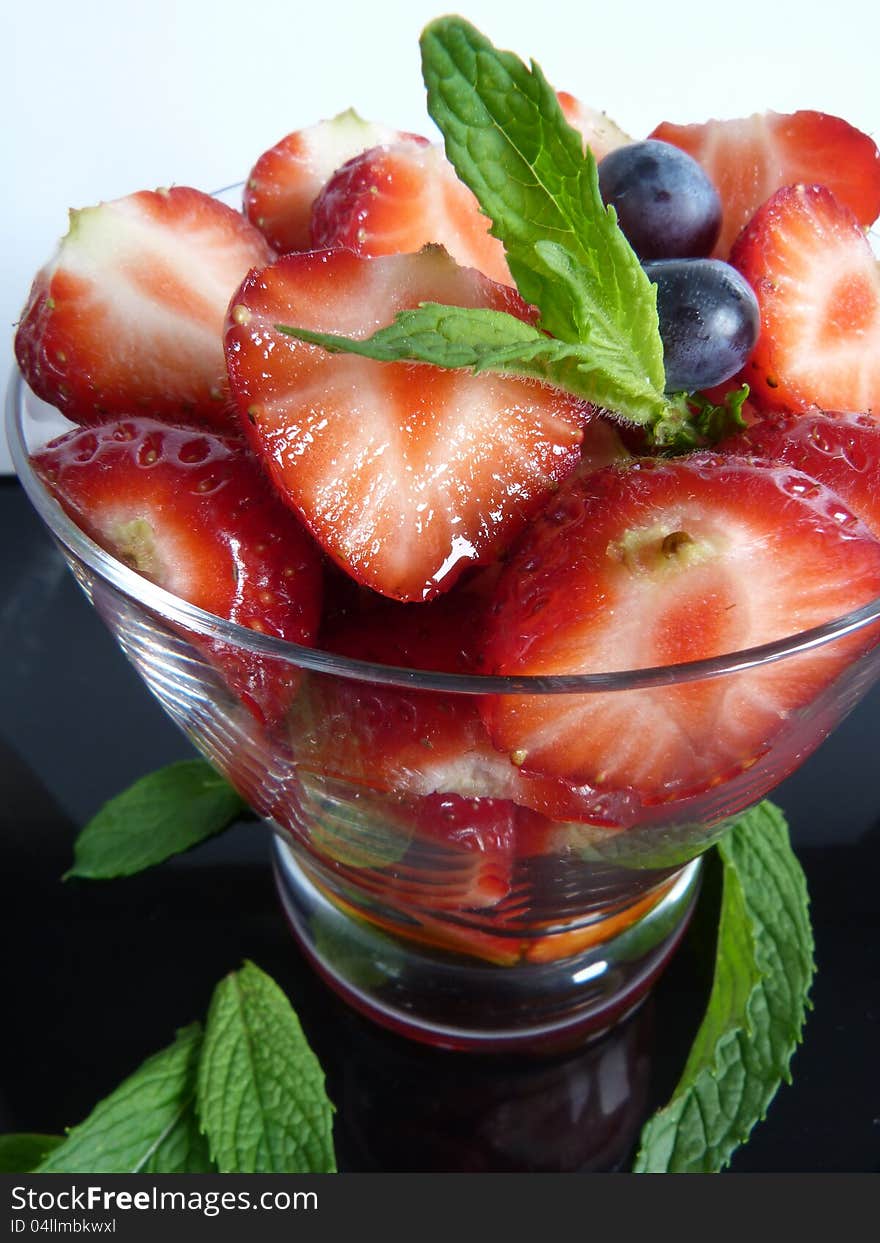 Close up of Strawberries and blueberries with a sprig of mint. Close up of Strawberries and blueberries with a sprig of mint