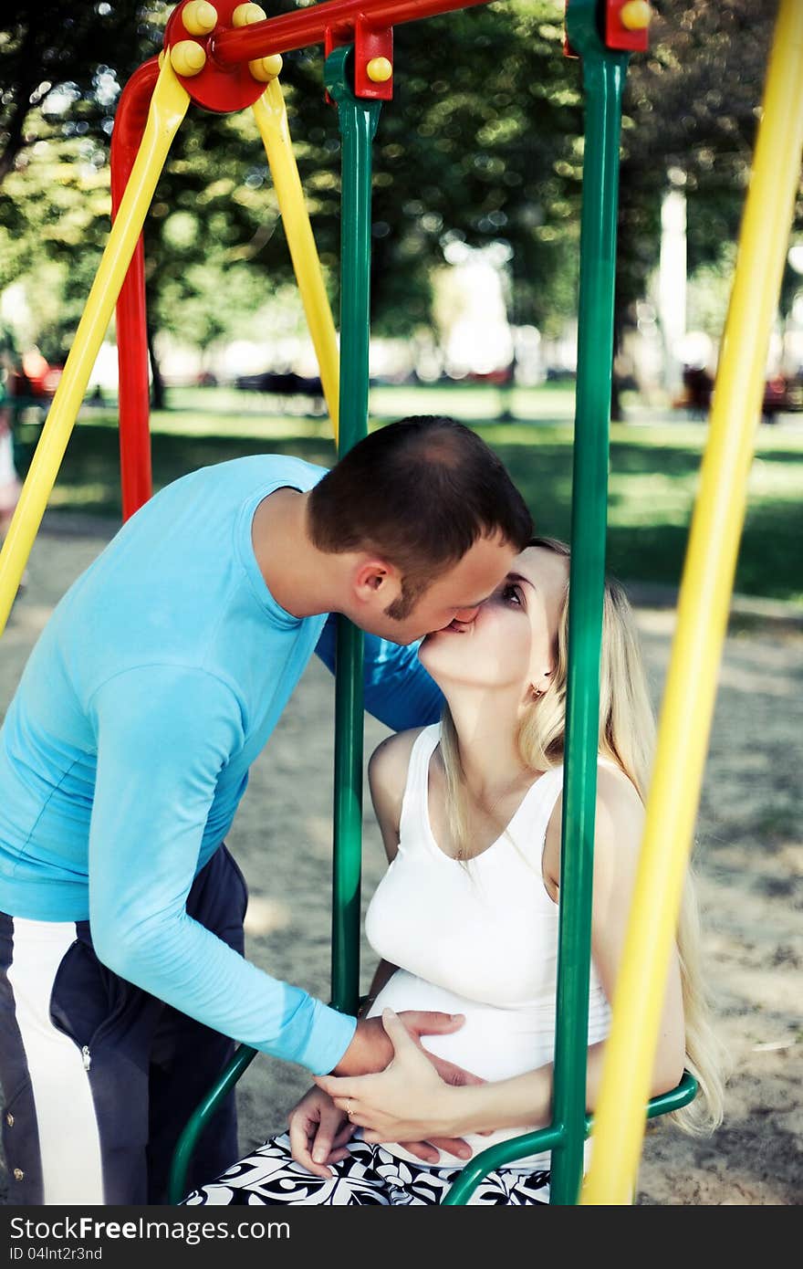 Parents kissing in the park. Parents kissing in the park