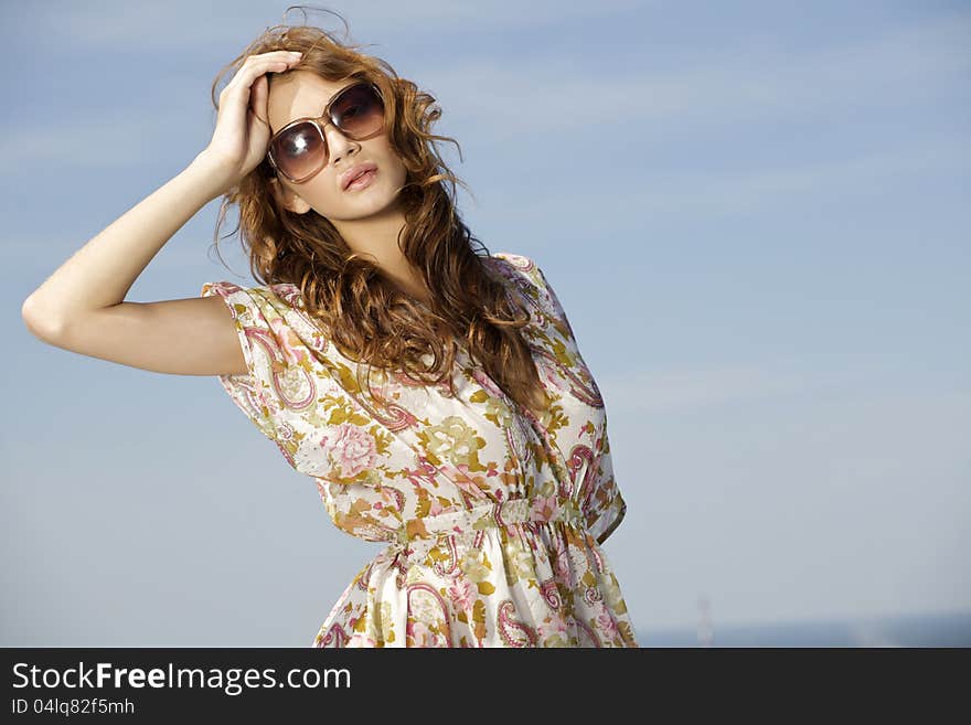 Beautiful girl in sunglasses on blue sky