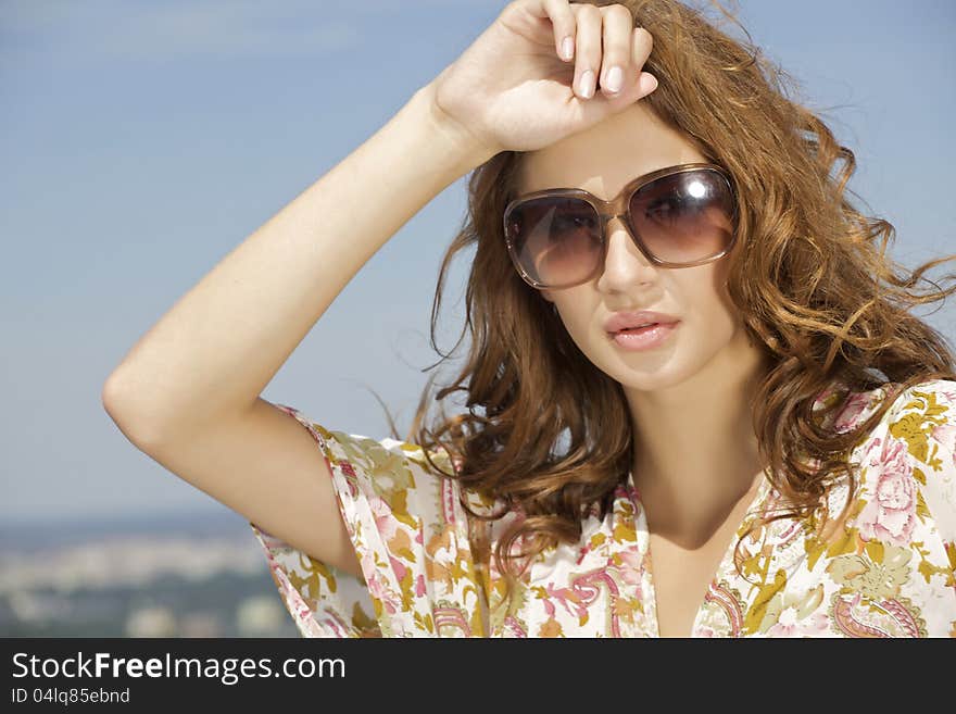 Beautiful girl in sunglasses on blue sky