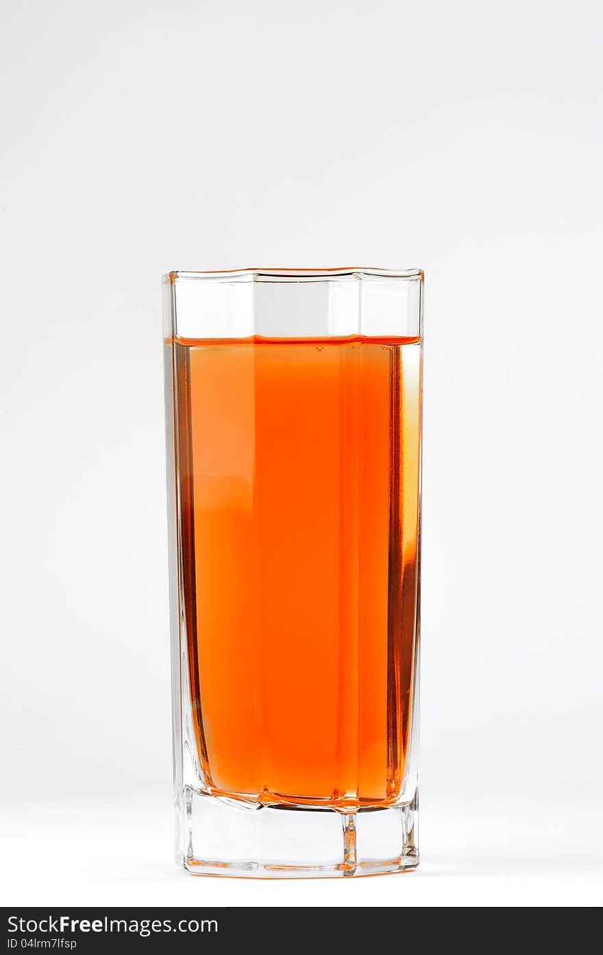 A glass with a red drink on a white background