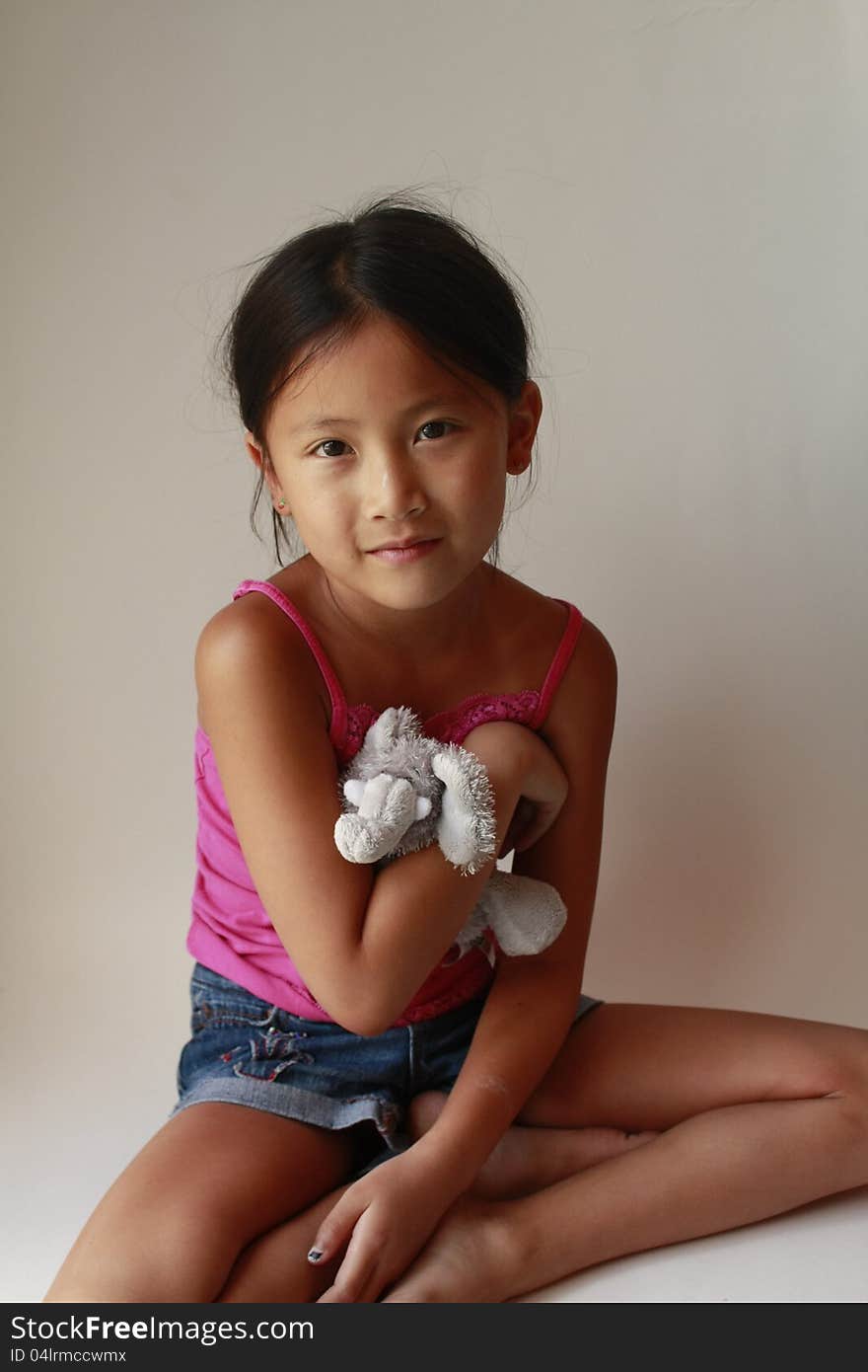 Little Chinese girl with stuffed elephant sitting down. Little Chinese girl with stuffed elephant sitting down