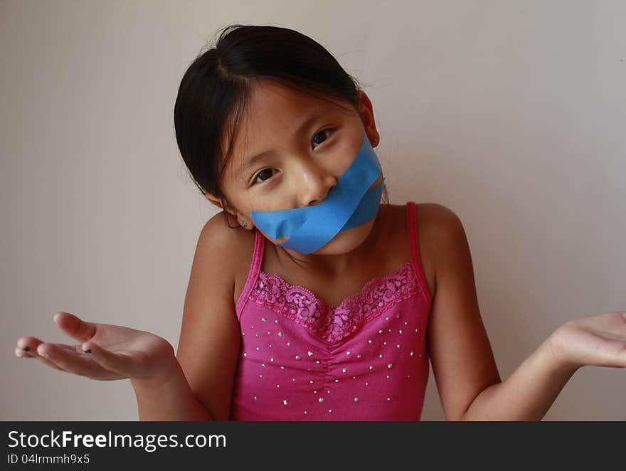 Funny little Chinese Asian girl with blue tape on mouth. Funny little Chinese Asian girl with blue tape on mouth