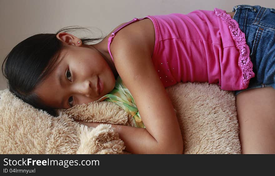 Little asian girl laying on a stuffed dog