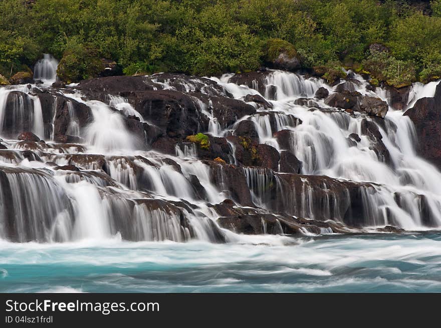 Wonderful cascade Hraunfossar waterfalls with green water in iceland. Wonderful cascade Hraunfossar waterfalls with green water in iceland