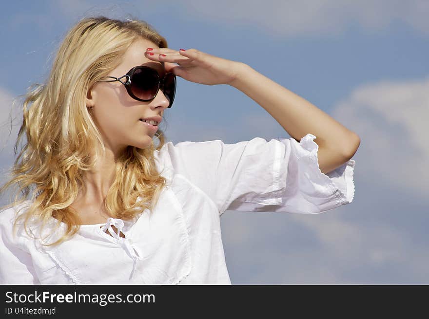 Beautiful girl in sunglasses on blue sky