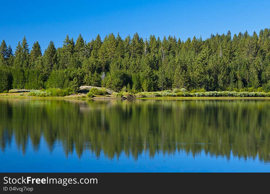 High sierra lake with mirror reflection and blue skies. High sierra lake with mirror reflection and blue skies