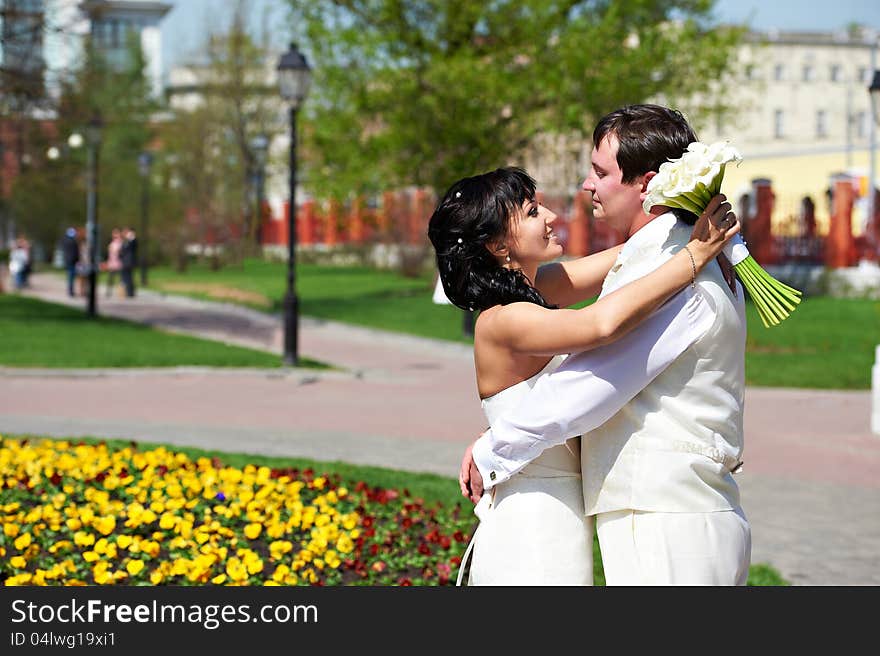 Happy groom and bride on wedding walk in the park