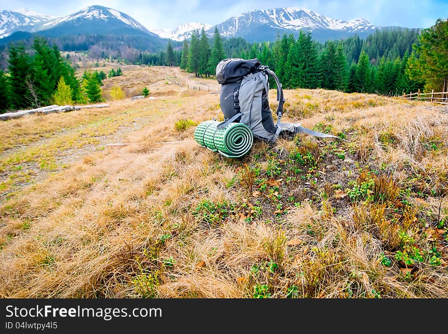 Tourists backpack in mountains landscape under blue sky