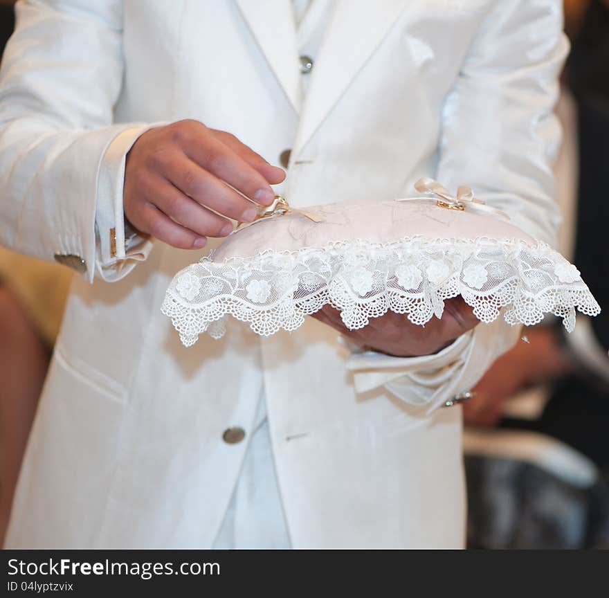 Wedding rings resting on white pillow