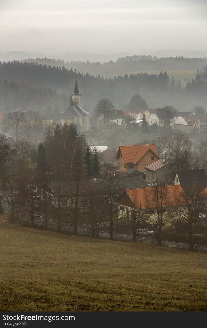 Czech village surrounded by woods in the early morning fog in autumn. Czech village surrounded by woods in the early morning fog in autumn