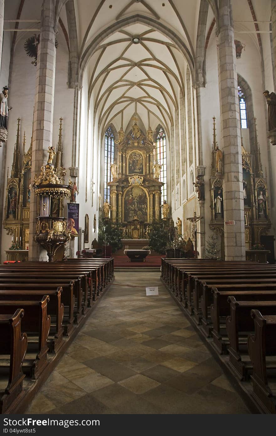 Cesky krumlov, inside of a church with rows of benches. Cesky krumlov, inside of a church with rows of benches