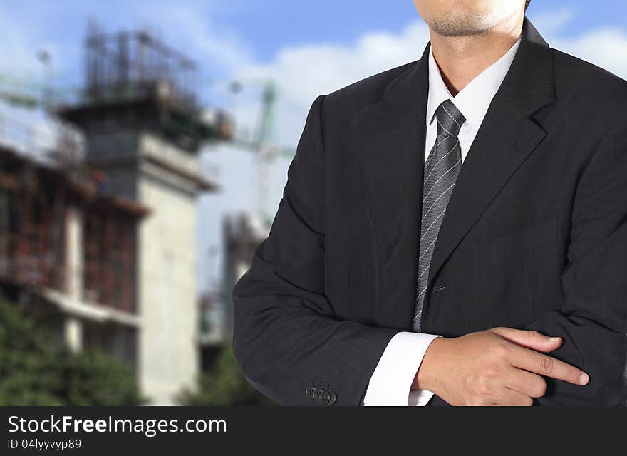 Cropped view of Businessman standing in front the construction