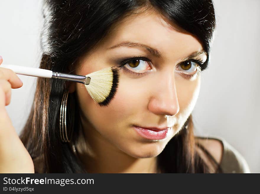 Portrait of beautiful young adult woman applying cosmetic. Portrait of beautiful young adult woman applying cosmetic