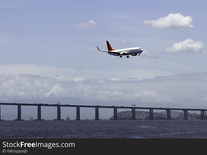 Airplane landing in Rio De Janeiro on the bridge background