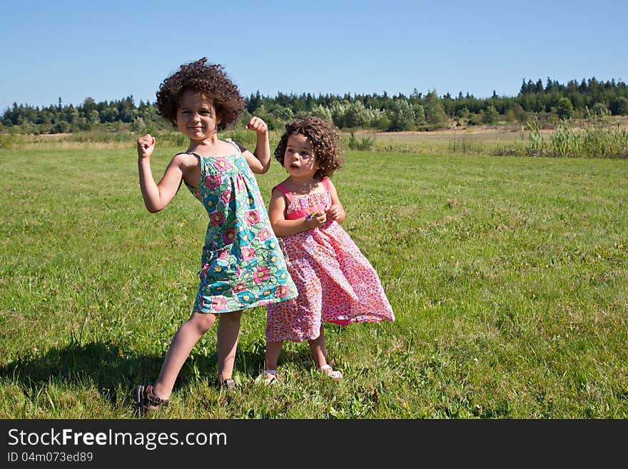 Young girl making muscle arms