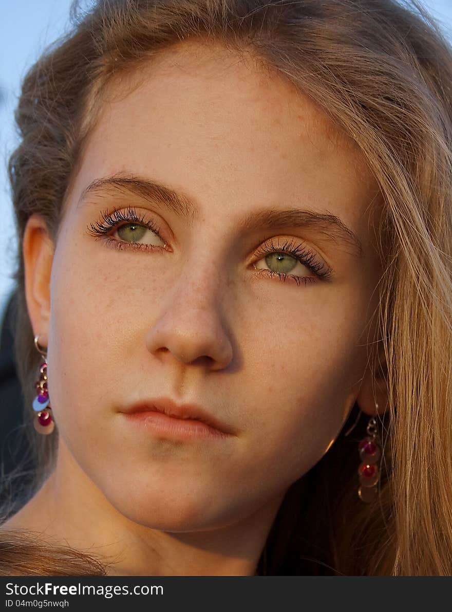 A closeup portrait of a green-eyed young blond female. A closeup portrait of a green-eyed young blond female.