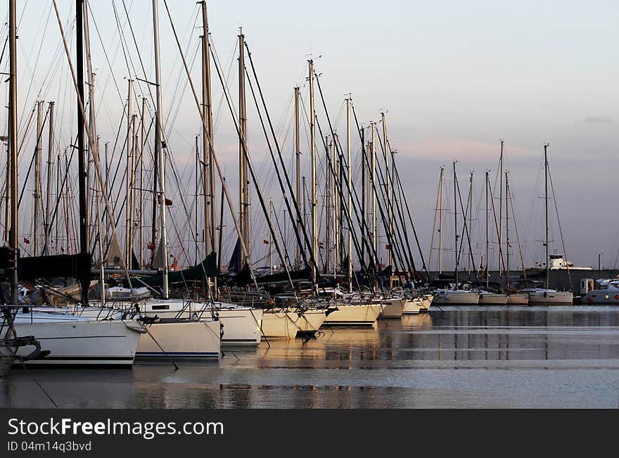 View of the marina and sunset sailing yachts. View of the marina and sunset sailing yachts