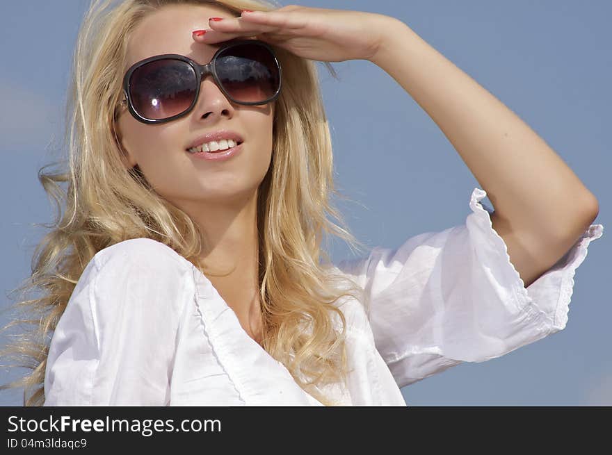 Beautiful girl in sunglasses on  blue sky