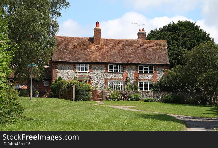 A Traditional English rural Brick and Flint House with footpath sign in front. A Traditional English rural Brick and Flint House with footpath sign in front